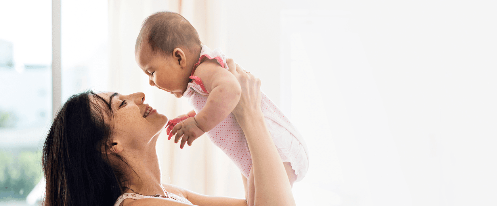 Mother lifting her baby joyfully
